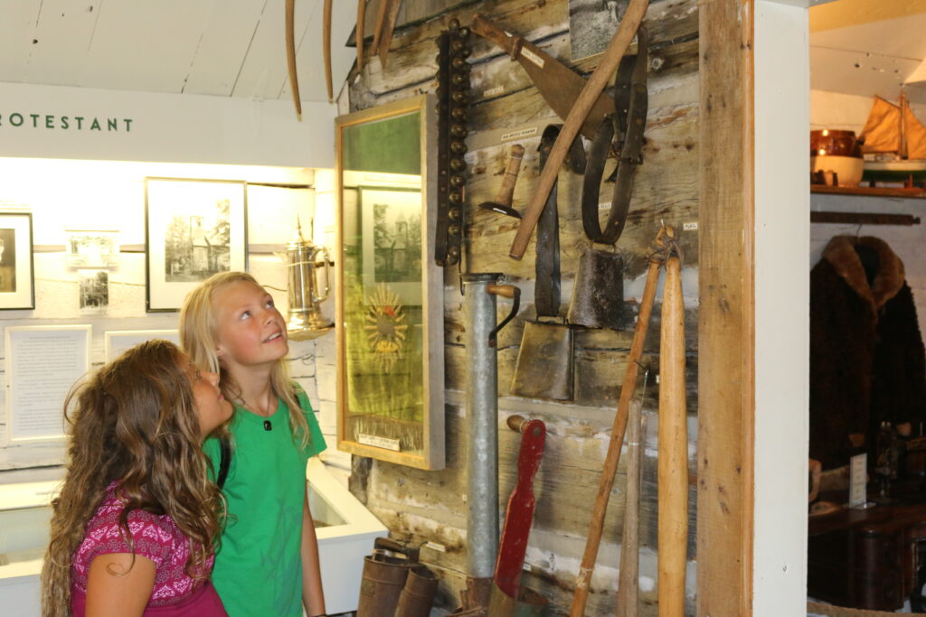 two girls looking at tools hung on a wall